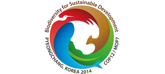 Grafik: Bunter Kreis mit roten, grünen, blauen und braunen Flächen. Drumherum steht: COP12/MOP7 Pyeongchang Korea 2014.