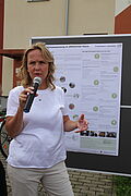 Steffi Lemke mit einem Mikrofon vor einer Tafel bei den Aktionstagen "Umwelt im Quartier"