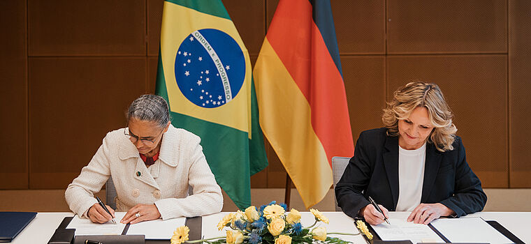 Steffi Lemke und Marina Silva unterschreiben ein Dokument.