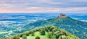 Blick auf die malerische Landschaft der Schwäbischen Alb mit Hügeln und einer Burg