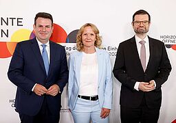 Steffi Lemke mit Hubertus Heil und Marco Buschmann vor einer Fotowand