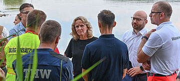 Bundesumweltministerin Steffi Lemke, und Rene Wilke (2.v.r.), Oberbürgermeister der Stadt Frankfurt Oder, besprechen mit Einsatzkräften die Lage.