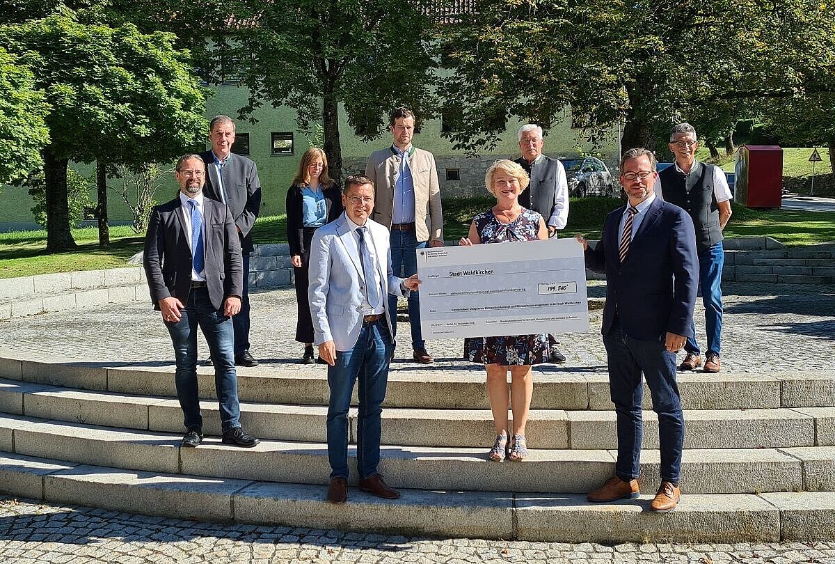 Der Parlamentarische Staatssekretär im BMU, Florian Pronold, überreicht einen Förderscheck an Vertreter der Gemeinde Waldkirchen