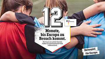 Bild: 3 Kinder von hinten, die Arme umeinander gelegt. Text: 12 MOnate, bis Europa zu Besuch kommt. Wir freuen uns auf den Start der Fußball-Europameisterschaft 2024 in Deutschland.