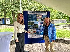 Steffi Lemke mit einer Frau vor einem Plakat