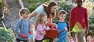 Gruppe von Kindern bei der Gartenarbeit mit einer Lehrerin