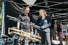 Steffi Lemke im Gespräch mit einer Person vor einem Motorrad