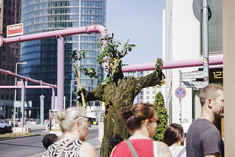 Die wandelnde Eiche und Menschen an einer Straßenkreuzung.