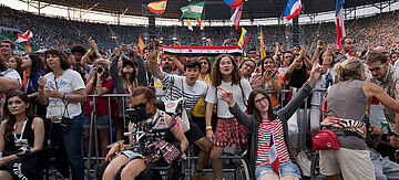 Fans im Stadion mit Flaggen