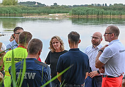 Bundesumweltministerin Steffi Lemke, und Rene Wilke (2.v.r.), Oberbürgermeister der Stadt Frankfurt Oder, besprechen mit Einsatzkräften die Lage.