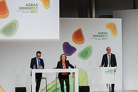  Steffi Lemke und Cem Özdemir stehen am Rednerpult. Rechts daneben der Moderator.