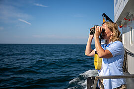 Steffi Lemka schaut durch ein Fernglas.